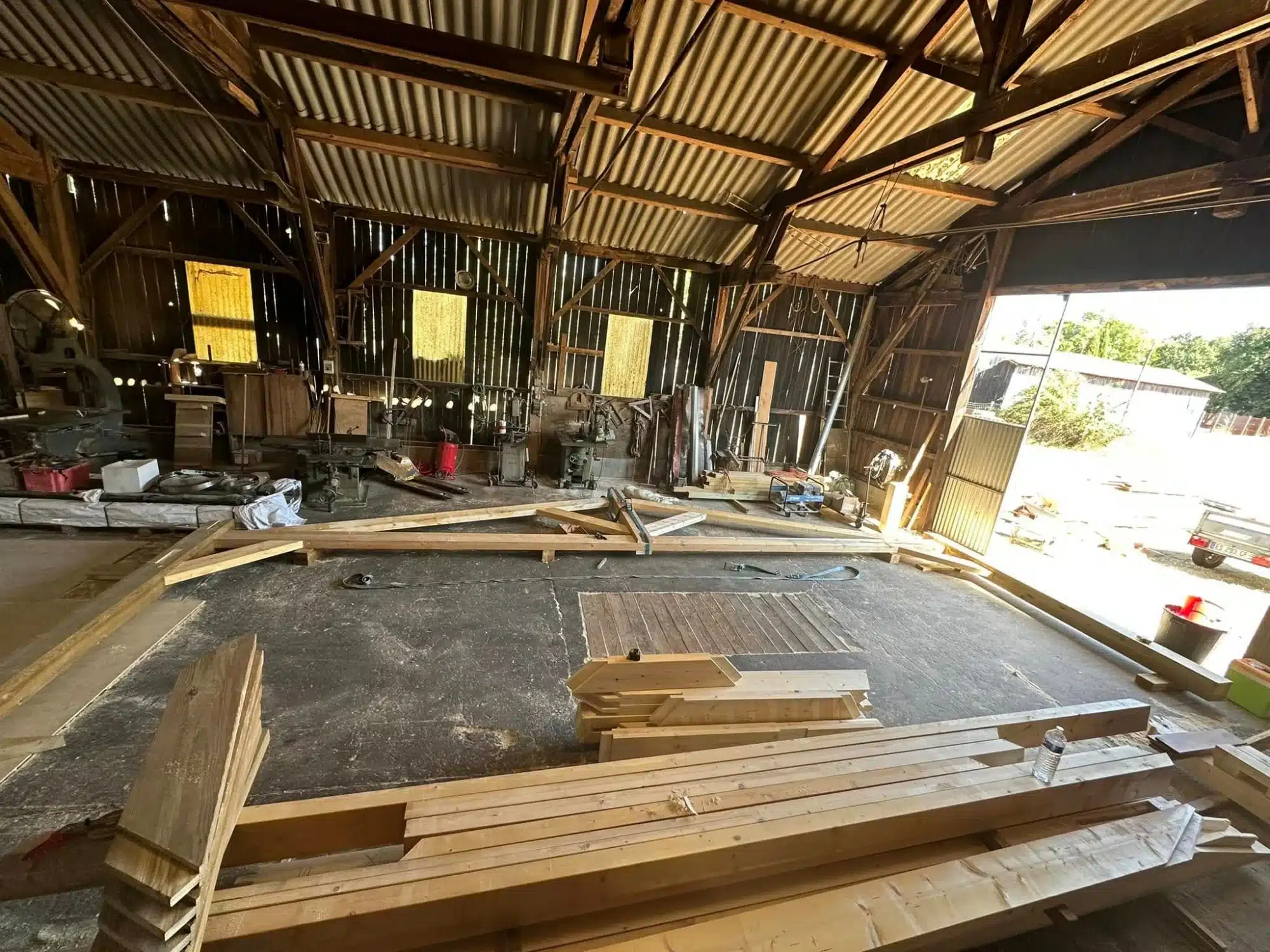 Charpente bois traditionnelle : Structure et ossature de toiture Charpente bois neuve symétrique. Ossature de toiture en poutres et chevrons s'élevant vers la faîtière, fond de ciel nuageux.