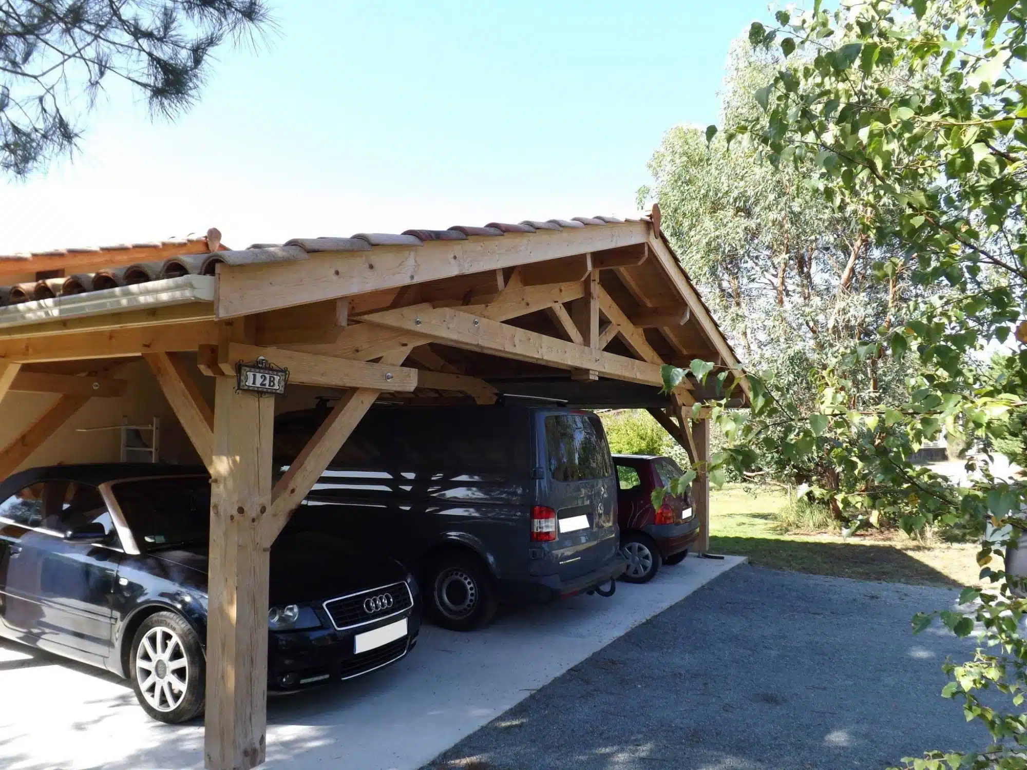 Charpente bois traditionnelle : Structure et ossature de toiture Charpente bois neuve symétrique. Ossature de toiture en poutres et chevrons s'élevant vers la faîtière, fond de ciel nuageux.