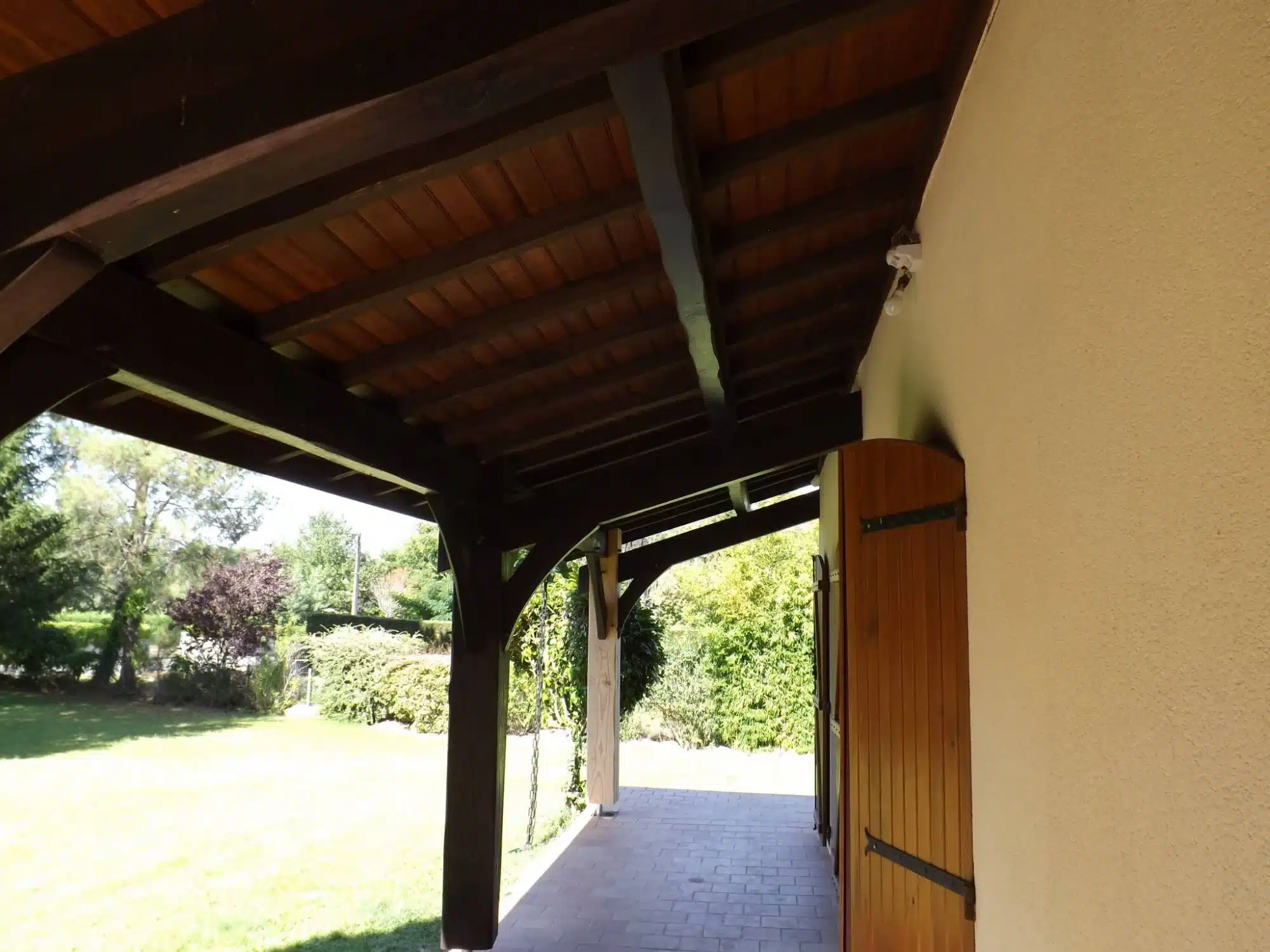 Charpente bois traditionnelle : Structure et ossature de toiture Charpente bois neuve symétrique. Ossature de toiture en poutres et chevrons s'élevant vers la faîtière, fond de ciel nuageux.